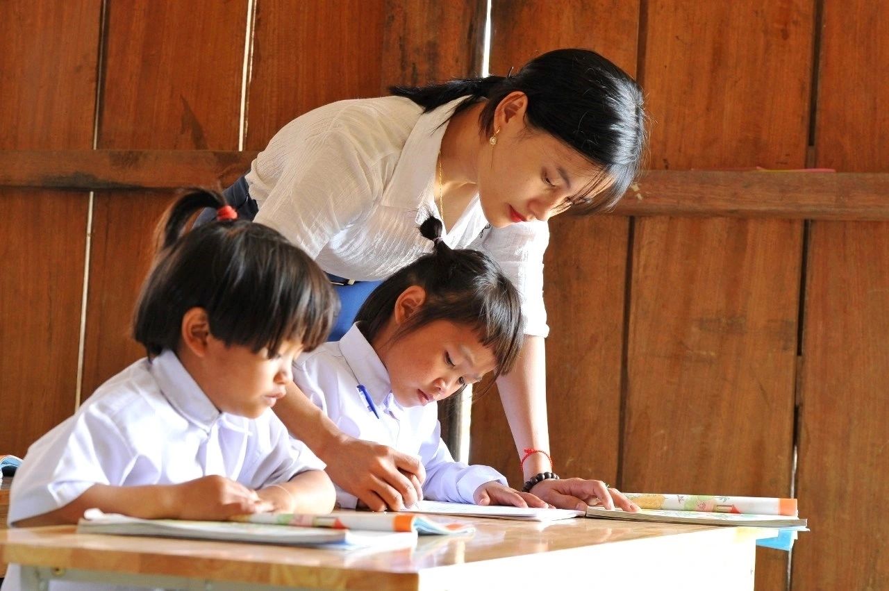 Cô giáo hướng dẫn học sinh vùng cao trong lớp học